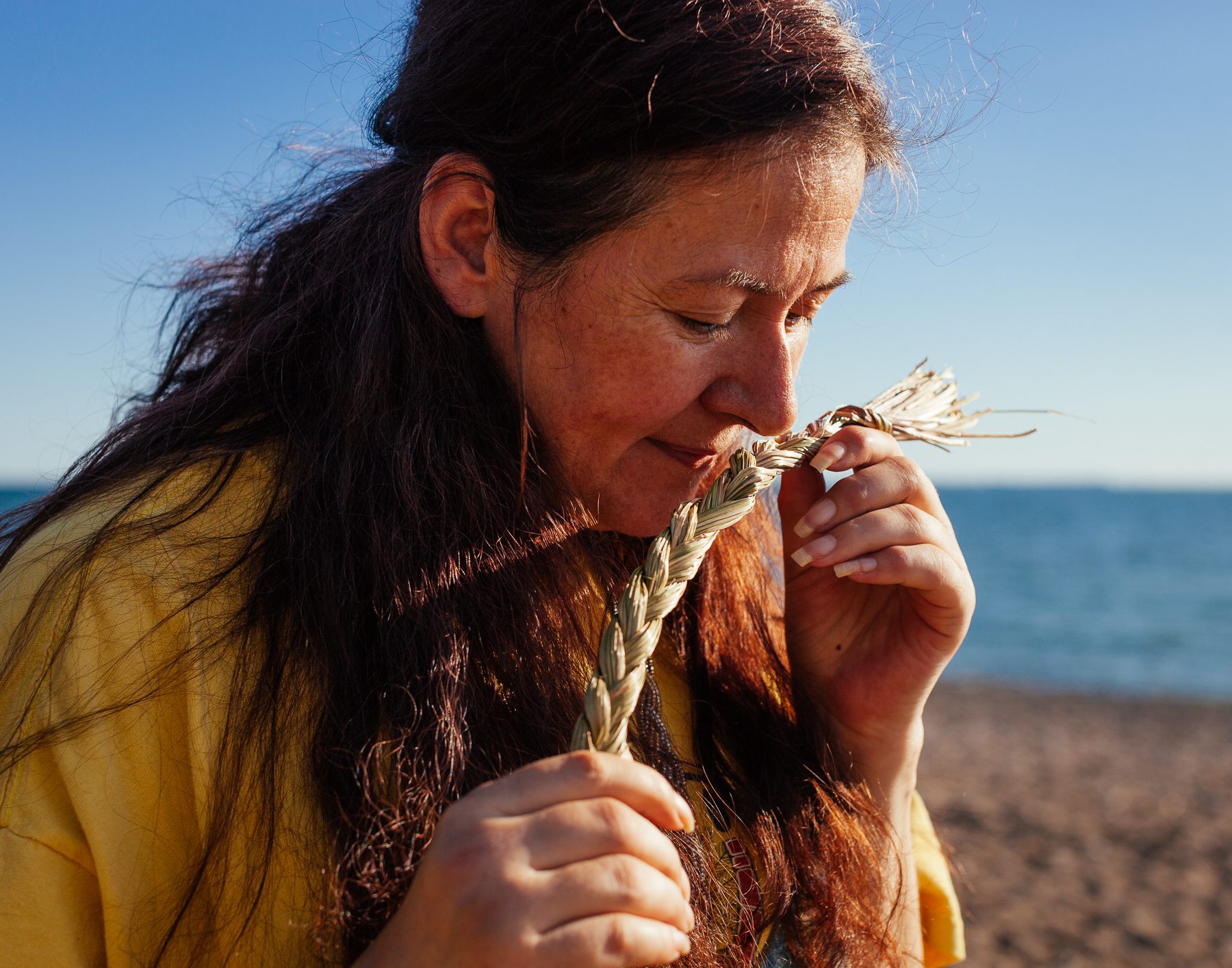 "Sweetgrass, for us, represents kindness. Its braids represent the hair of mother earth.” Carrie Ann explains how the sweetgrass is prepared using 21 blades — each of the three braids made of seven blades. The first section of seven blades represents the seven generations behind, the second, the Seven Sacred Teachings, and the third, the seven generations ahead" /Photo by Colin Boyd Shafer