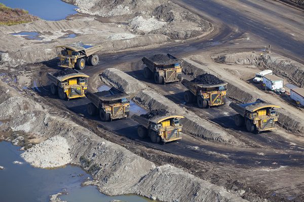 Aerial photo of a large dump trucks parked at a mine staging area. Canada's Oilsands, near Fort McMurray, Alberta.