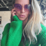 selfie of a woman with blonde hair wearing a green sweater